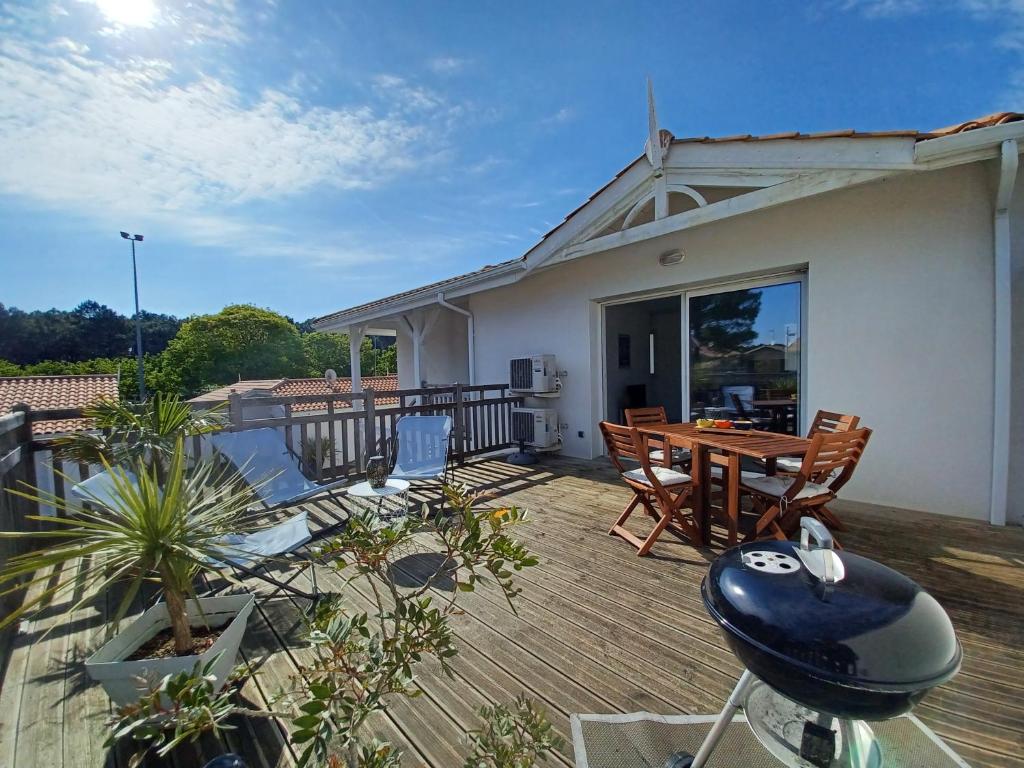 un patio avec une table et des chaises sur une terrasse dans l'établissement Patio de Flore, à Mimizan