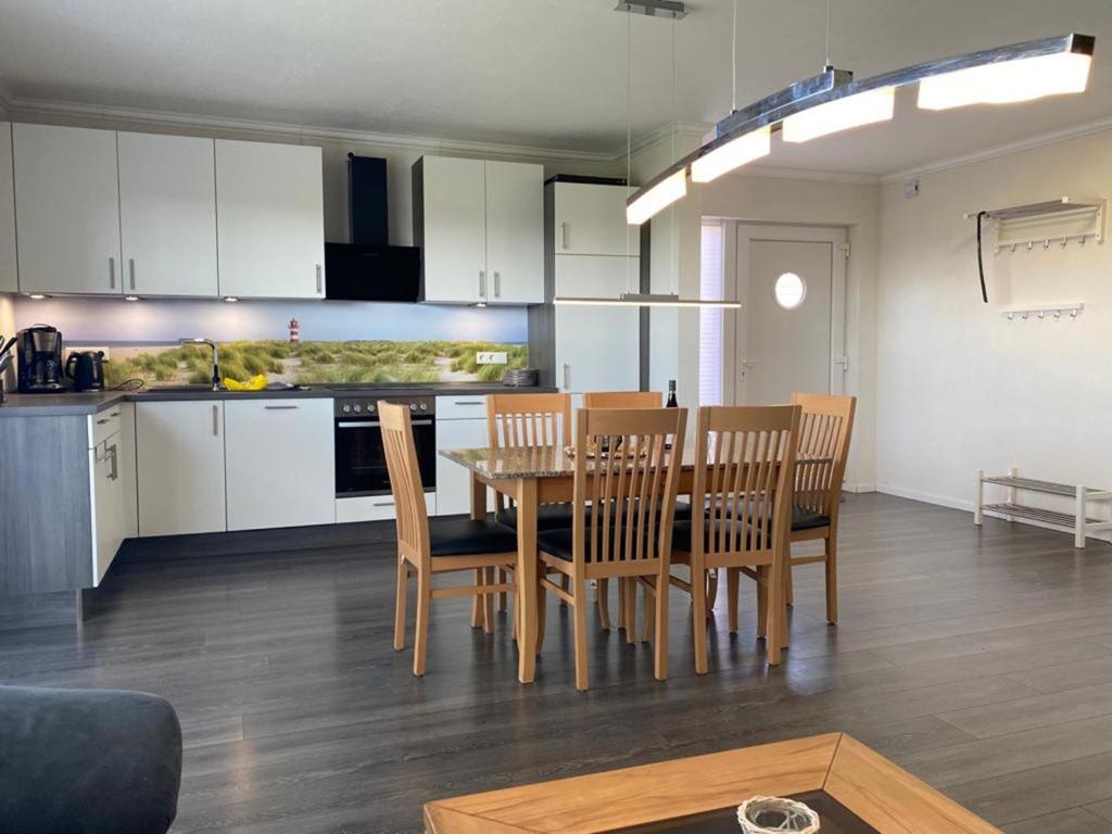 una cucina e una sala da pranzo con tavolo e sedie di Ferienhaus Familiennest a Sehestedt