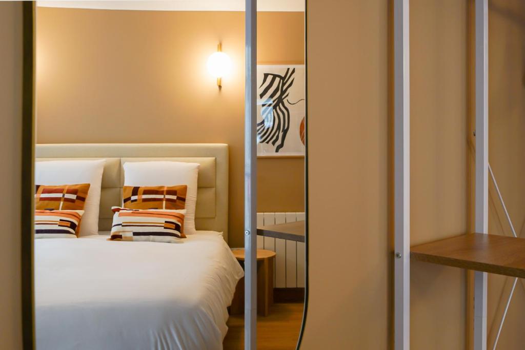 une chambre avec un lit et un miroir dans l'établissement Duplex climatisé - Grands Boulevards, à Paris