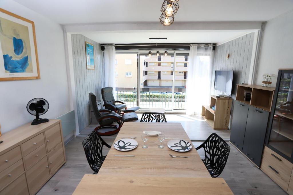 un salon avec une table et des chaises en bois dans l'établissement Superbe appart cosy au ceur de St Cyprien, à Saint-Cyprien