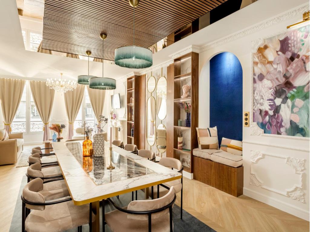 une salle à manger avec une longue table et des chaises dans l'établissement Merveil - Luxury Suite - Louvre - Michodiere, à Paris