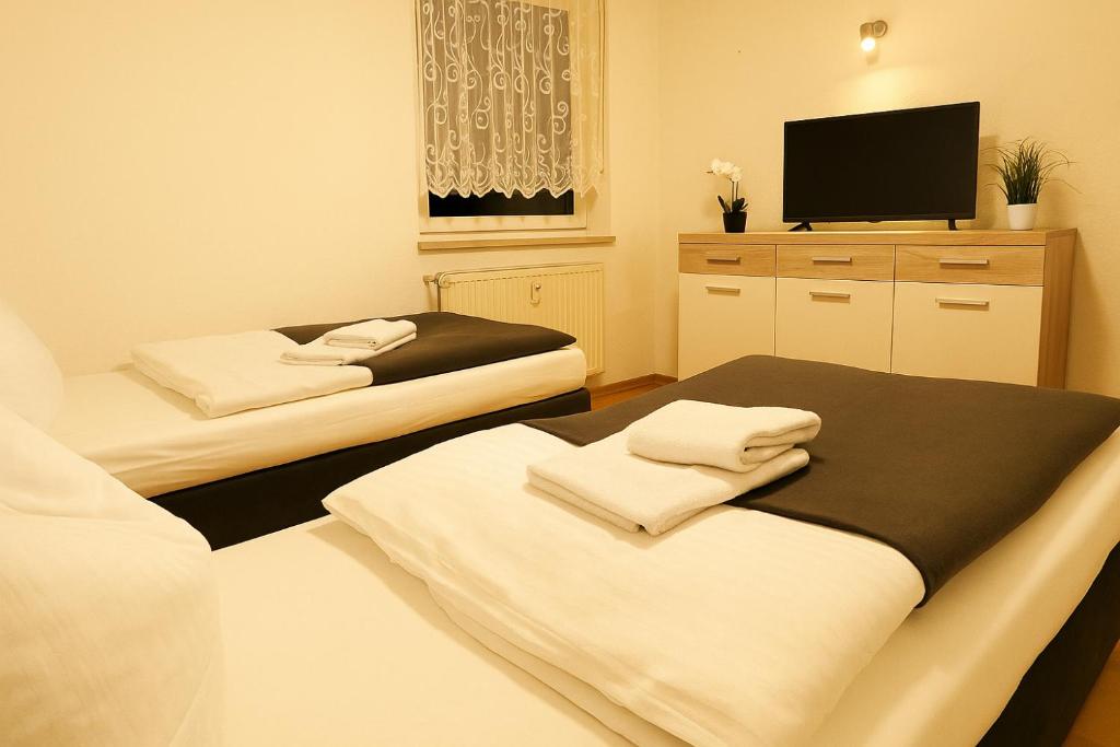 a room with two beds and a flat screen tv at SUNNYHOME Monteurwohnungen und Apartments nahe Regensburg in Nittendorf