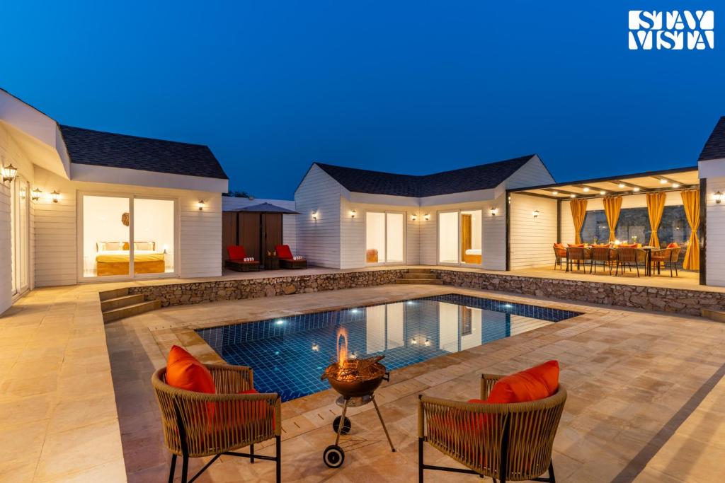 a swimming pool in a villa at night at StayVista at The Leo's Manor with Bonfire, Pool in Jaipur