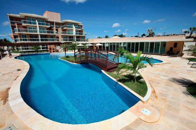 uma grande piscina em frente a um edifício em Palm Beach Apartamento 205 em Aquiraz