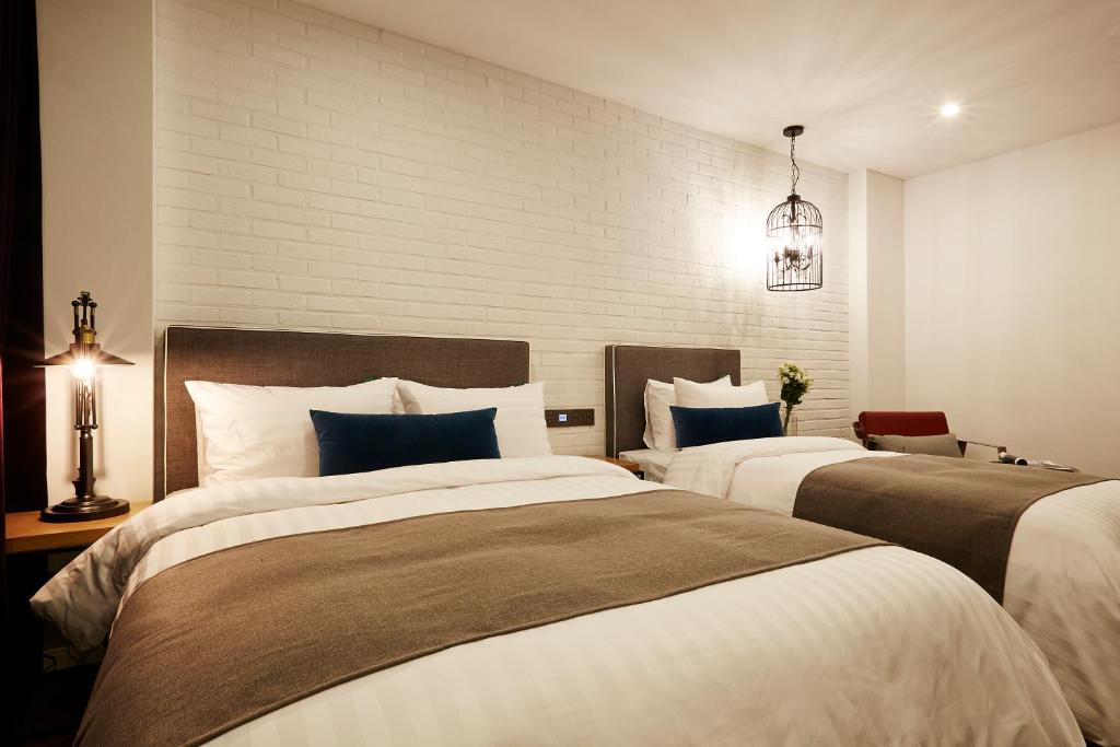 a bedroom with two beds and a lighted at Urban Island Hotel Jeju in Jeju