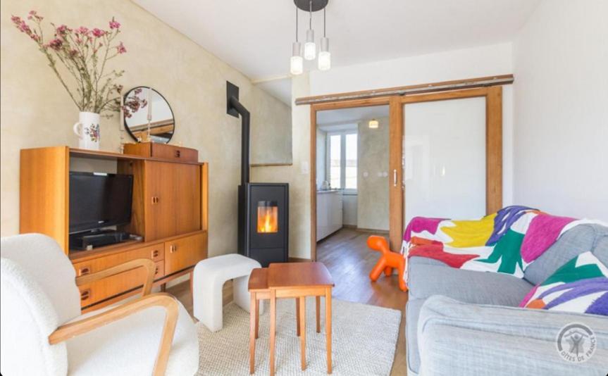 ein Wohnzimmer mit Sofa und Fernseher in der Unterkunft Charmante maison du vieux Coutainville, à 15mn à pied de la mer, classée 3 étoiles in Agon Coutainville