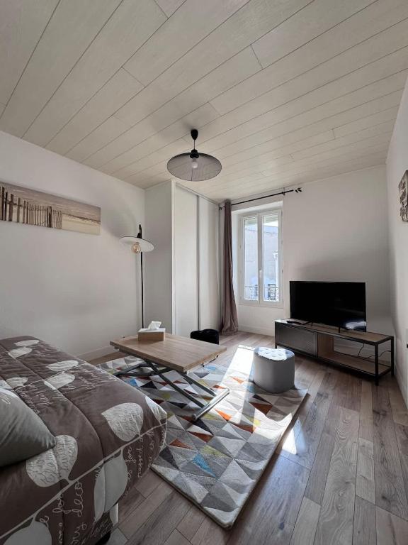 une chambre avec un lit, une table et une télévision dans l'établissement Appartement de la Lanterne - Résidence des Marées, à Aytré