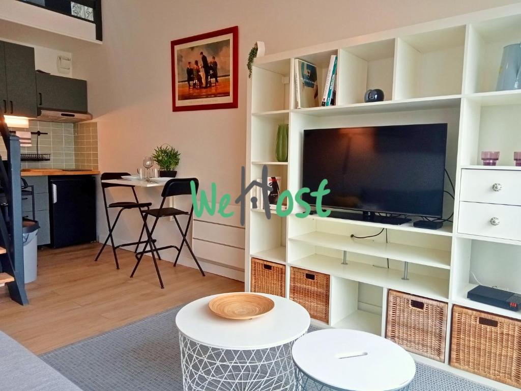 - un salon avec un grand centre de divertissement et une télévision dans l'établissement Bastion Studio central duplex parking, à La Rochelle