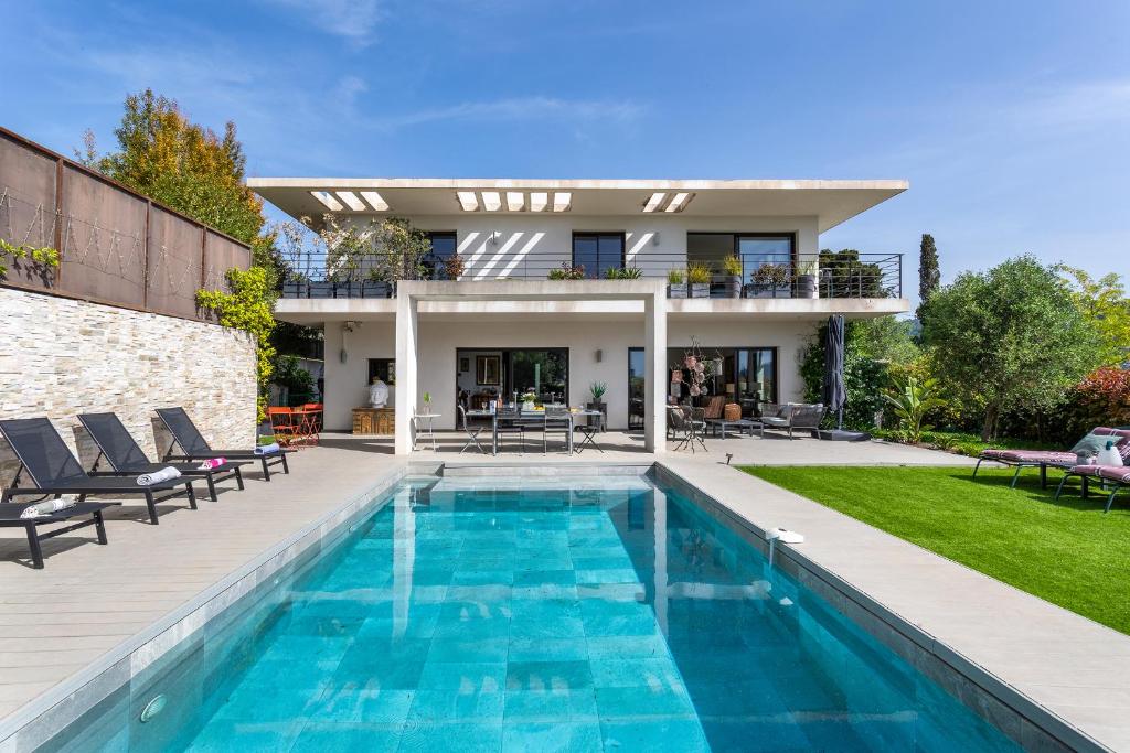 une maison avec une piscine devant une maison dans l'établissement Villa Les Sources VI4245 By Riviera Holiday Homes, à Nice