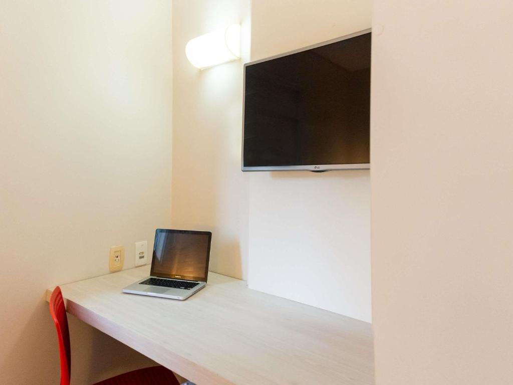 Uma TV ou centro de entretenimento em ibis Styles Belem Nazare