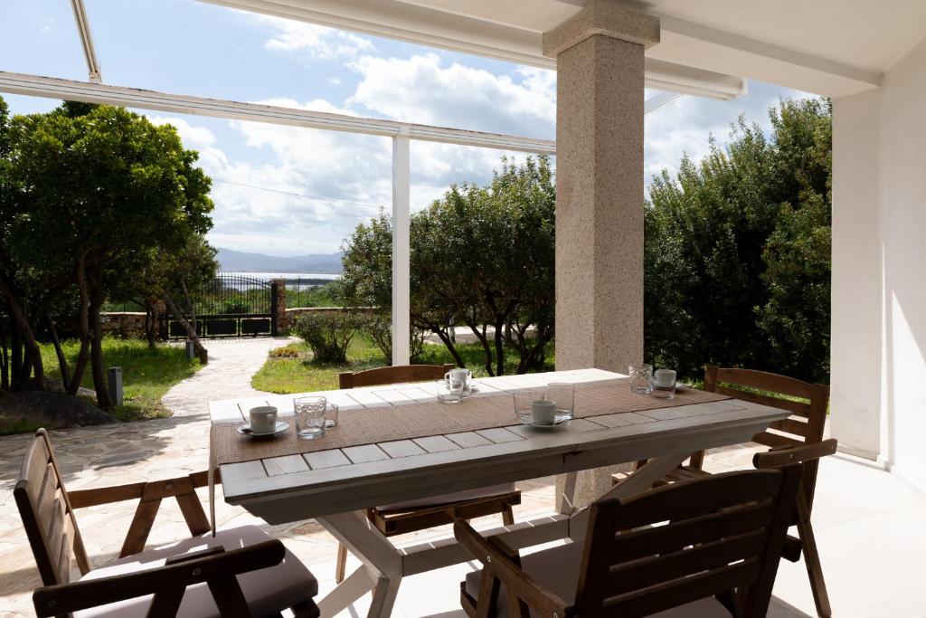 ein Holztisch und Stühle auf einer Terrasse in der Unterkunft Villetta Otis by Wonderful Italy in San Teodoro