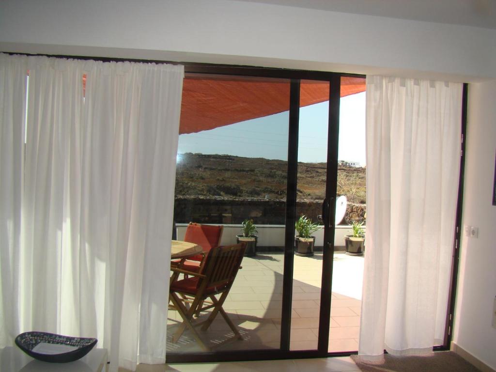 a room with sliding glass doors with a table and chairs at Villa Atlantis in Las Breñas