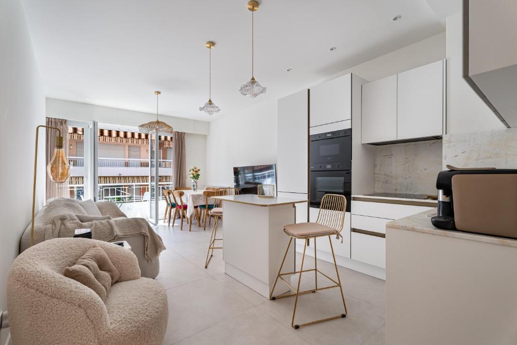 Il comprend une cuisine et un salon avec des placards blancs. dans l'établissement Rose des Sables - 4min à pied de la Plage, à Antibes