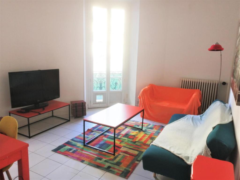 un salon avec une télévision et une table dans l'établissement Appartement 110m2 Nice plein centre, à Nice
