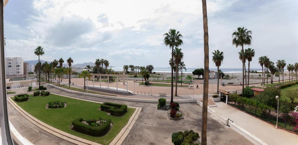 a view of a park with palm trees and the ocean at Comeback LOOKING FOR THE SUMMER in Motril