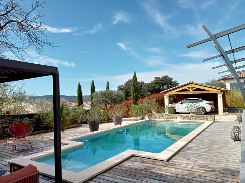 une piscine dans un jardin avec une voiture garée à côté dans l'établissement La villa du Pont du Gard, à Castillon-du-Gard
