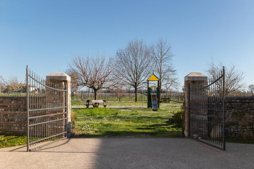 otwarta brama w parku z ławką parkową w obiekcie Agriturismo Mulino Delle Tolle w mieście Bagnário Arsa
