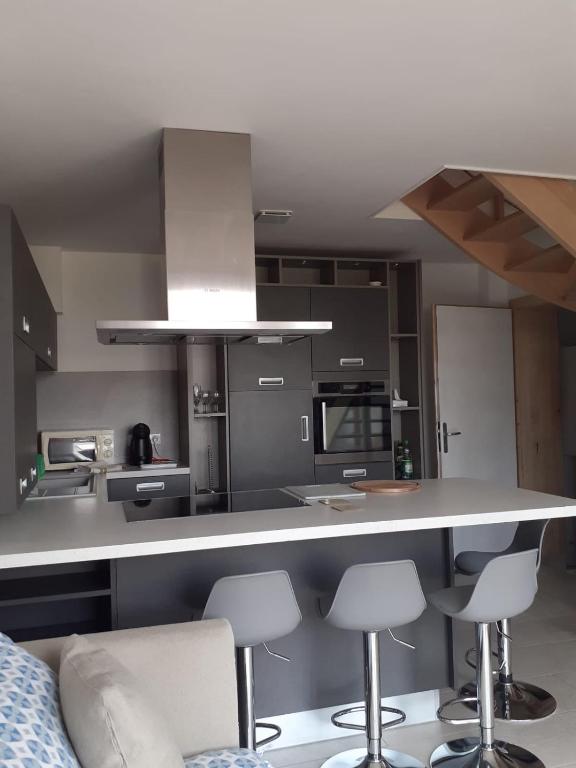 - une cuisine avec un comptoir et quelques tabourets dans l'établissement Le Rivage, à Excenevex