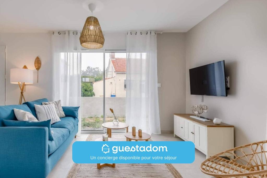 a living room with a blue couch and a window at Clair Jeanne - 900m plage - Parking in Notre-Dame-de-Monts