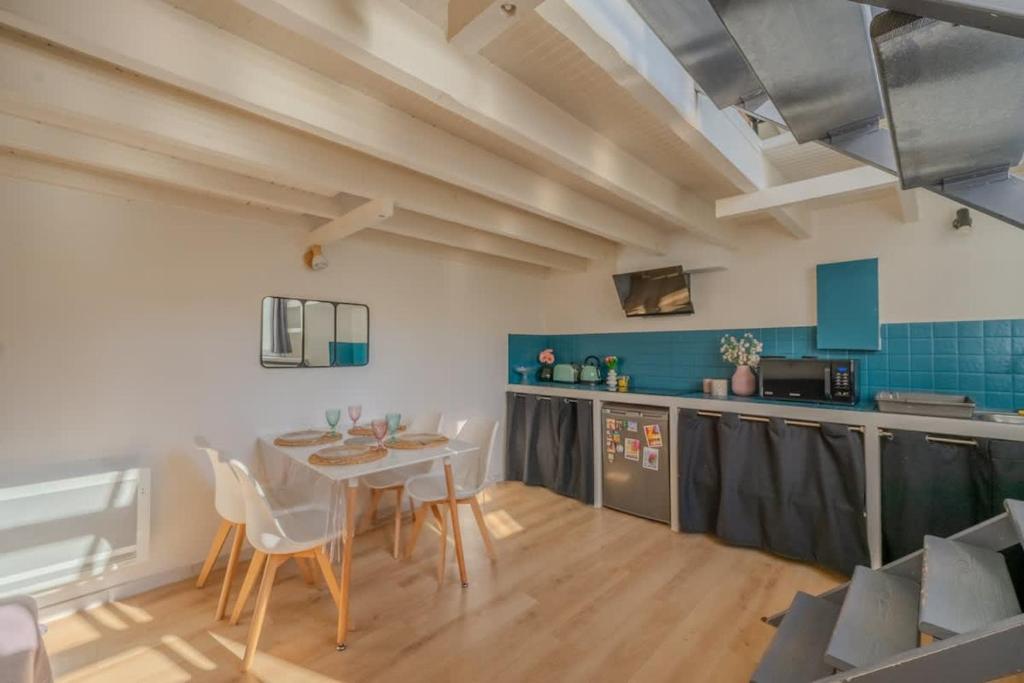 une cuisine et une salle à manger avec une table et des chaises dans l'établissement Appartement Samuel, à La Rochelle