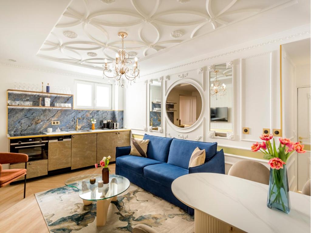 un salon avec un canapé bleu et une table dans l'établissement Merveil - Luxury Suite - Notre Dame - Boulangers, à Paris