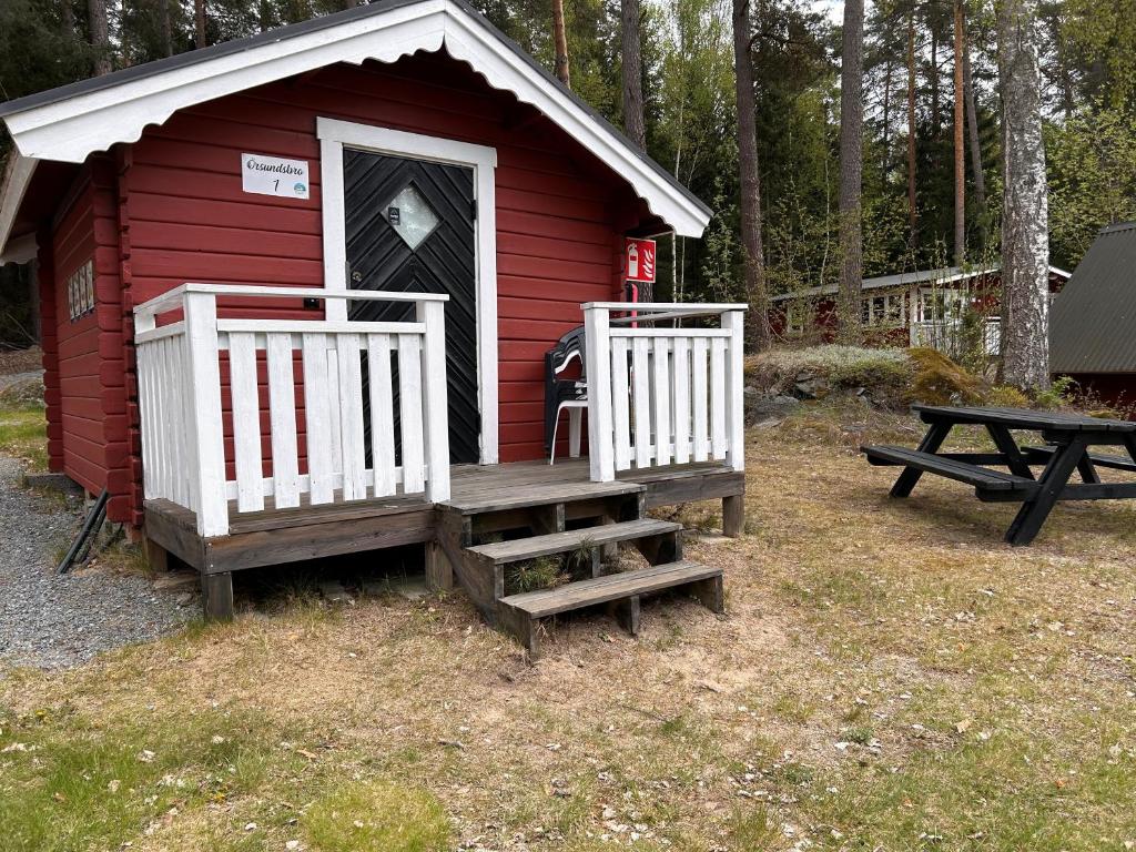 a red house with a bench and a picnic table at Klippertorp in Enköping