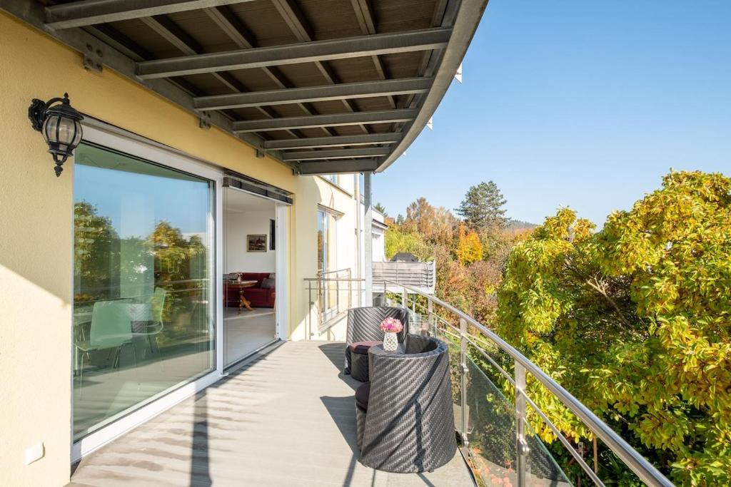 a balcony of a house with chairs and awning at Ferienwohnung Ankerplatz in Überlingen