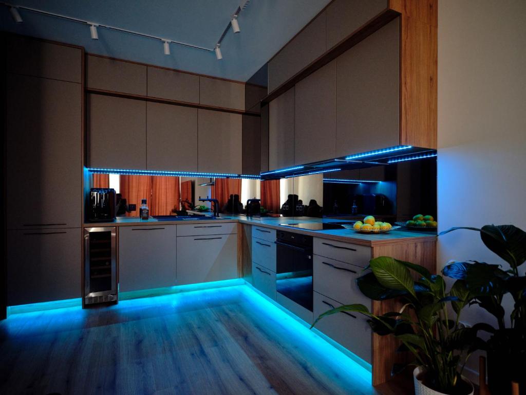 a kitchen with blue led lighting in a kitchen at Luxusowy Apartament Staszica in Koszalin