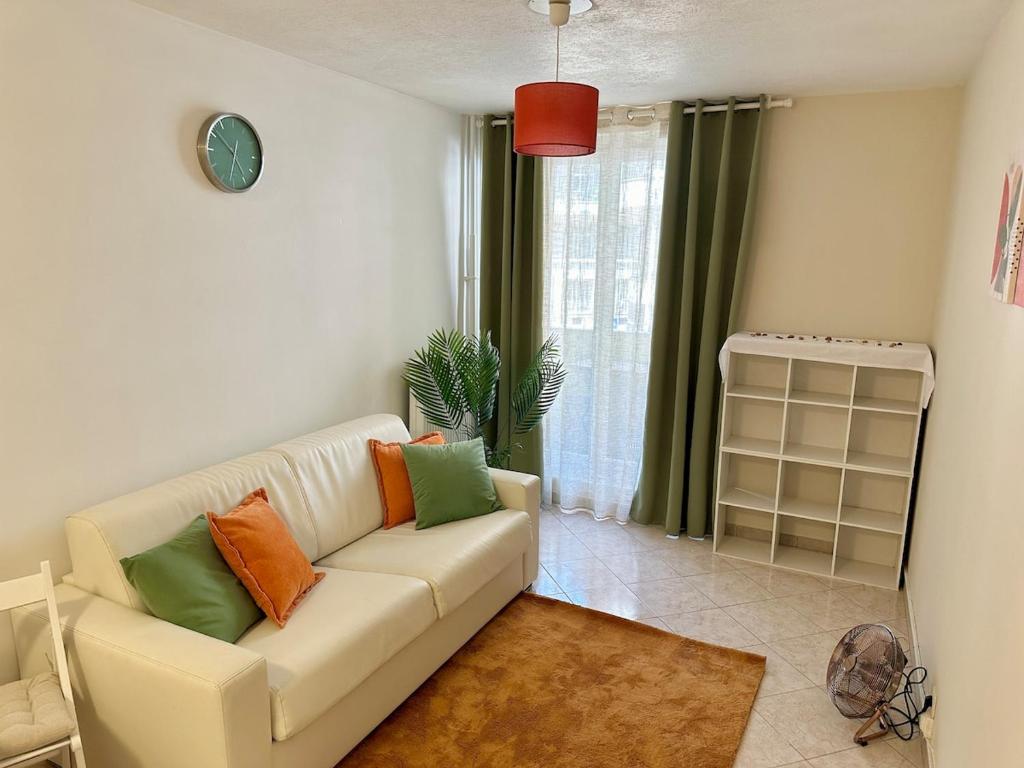- un salon avec un canapé blanc et des oreillers colorés dans l'établissement Studio Riviera - balcon et Wifi, à Nice