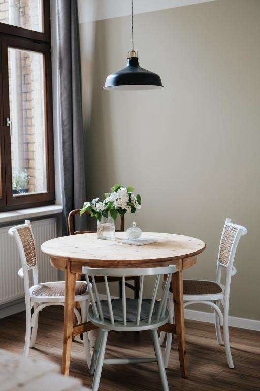 a dining room table with chairs and a pendant light at Ferienwohnungen "Hermann & Lucy" in Bad Muskau