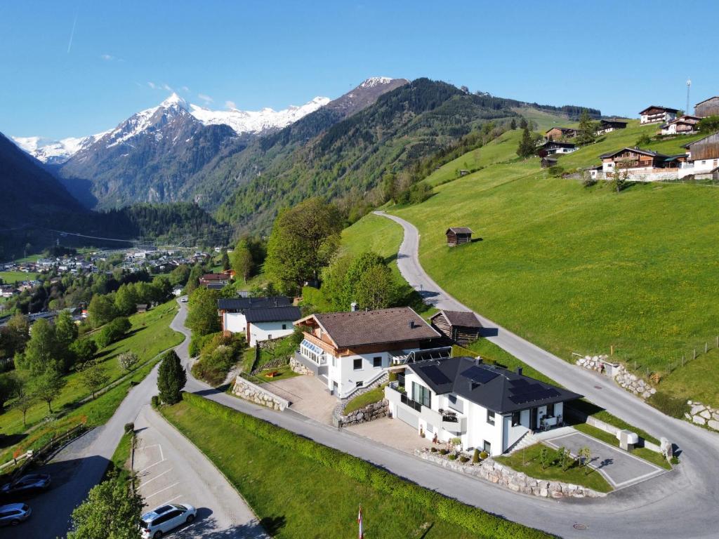 z góry widok na dom na wzgórzu z górami w obiekcie Appartement Haus Talblick w Kaprunie