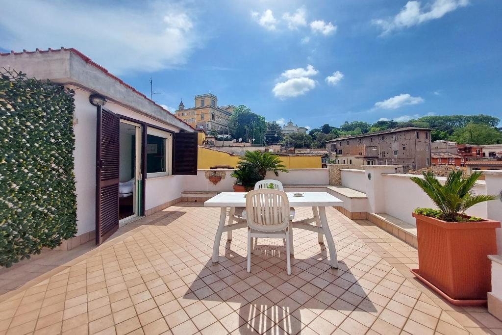 a white table and a chair on a balcony at Magic Trastevere suite on roof terrace in Rome