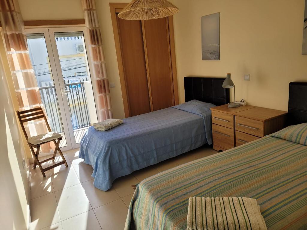 a hotel room with two beds and a balcony at A Cabaninha - T2 Cabanas Beach in Tavira