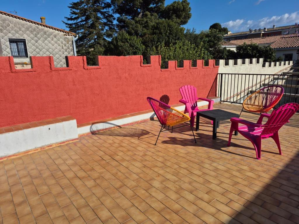 3 chaises et une table sur une terrasse dans l'établissement Apartement La Cuverie, à Carcassonne