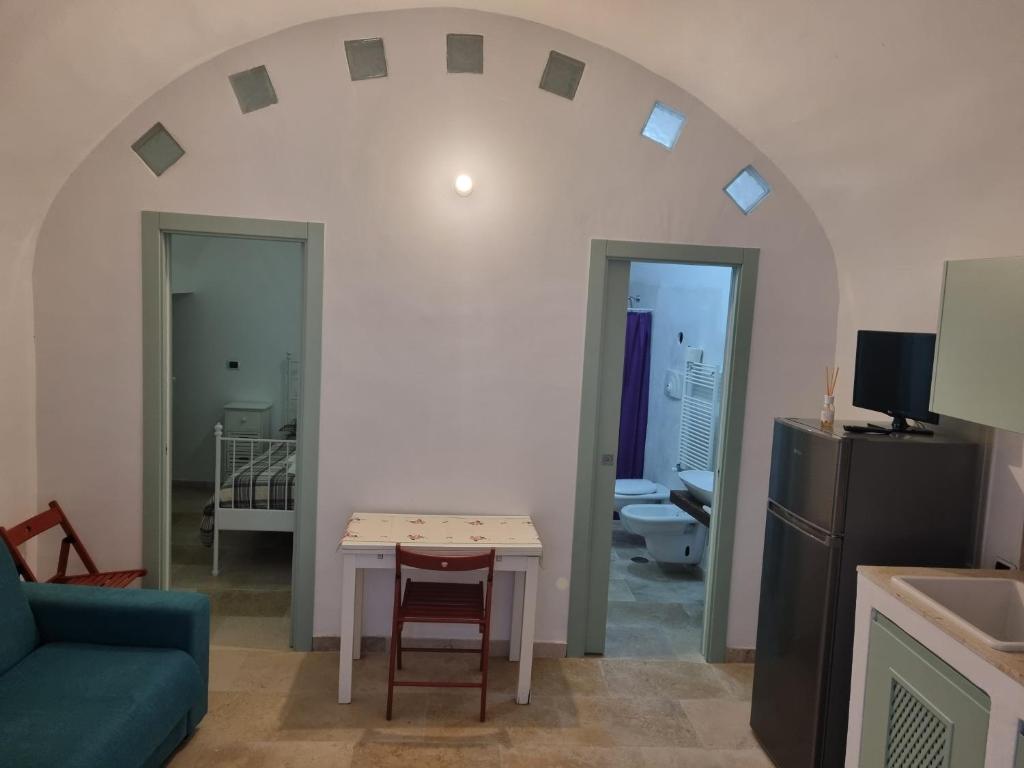 a living room with a table and a blue couch at Dimora di Ponente in Ostuni