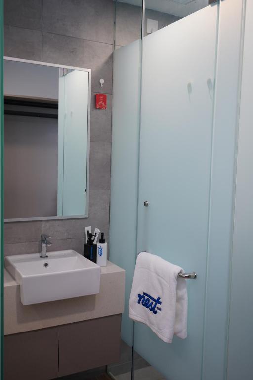 a bathroom with a sink and a mirror at Nest Retreat Kuala Lumpur in Kuala Lumpur