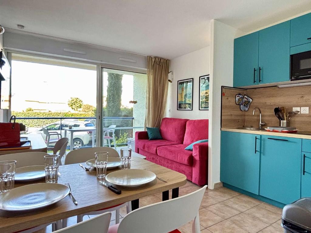 Il comprend une cuisine et un salon avec une table et un canapé rouge. dans l'établissement Appartement 2 pièces Résidence Mer et Golf au Port d'Argelès sur Mer AR045-C64, à Argelès-sur-Mer