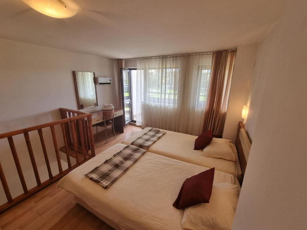a small bedroom with two beds and a balcony at Mountain Paradise 1 - 1 Bright Two Floor Apartment - wifi -balcony in Bansko