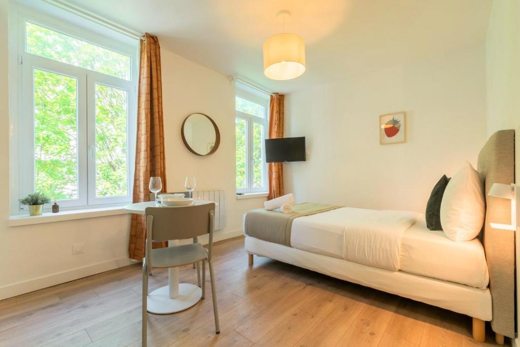 sypialnia z łóżkiem i stołem z krzesłem w obiekcie Lille Sébastopol nice studio w Lille