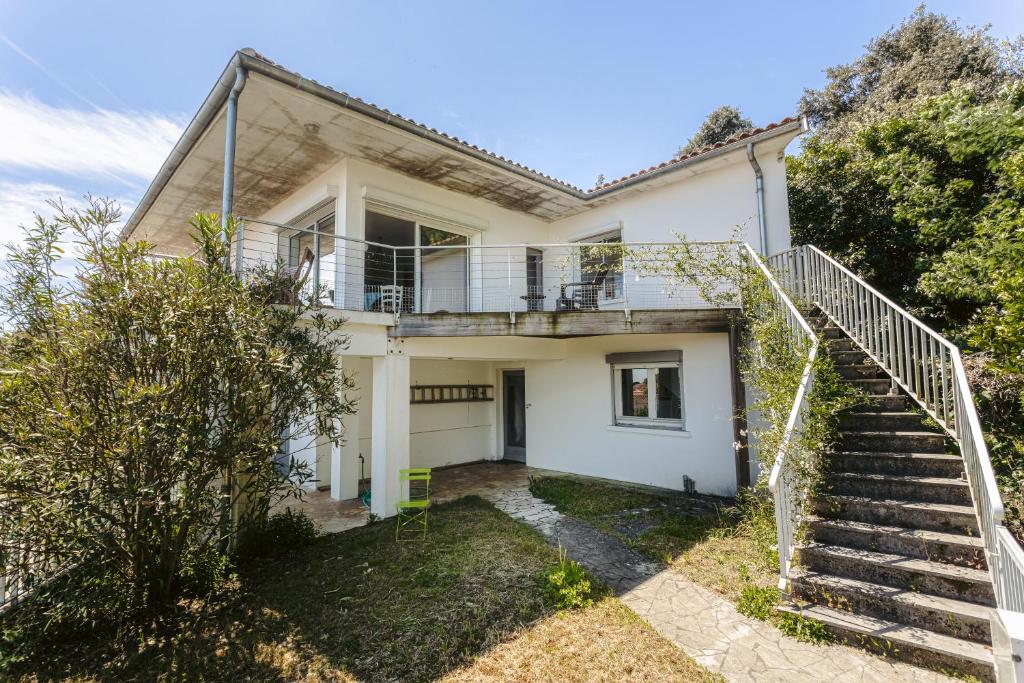 une maison blanche avec un escalier en face de celle-ci dans l'établissement Maison Bordure de Forêt et vue Mer, à Saint-Trojan-les-Bains
