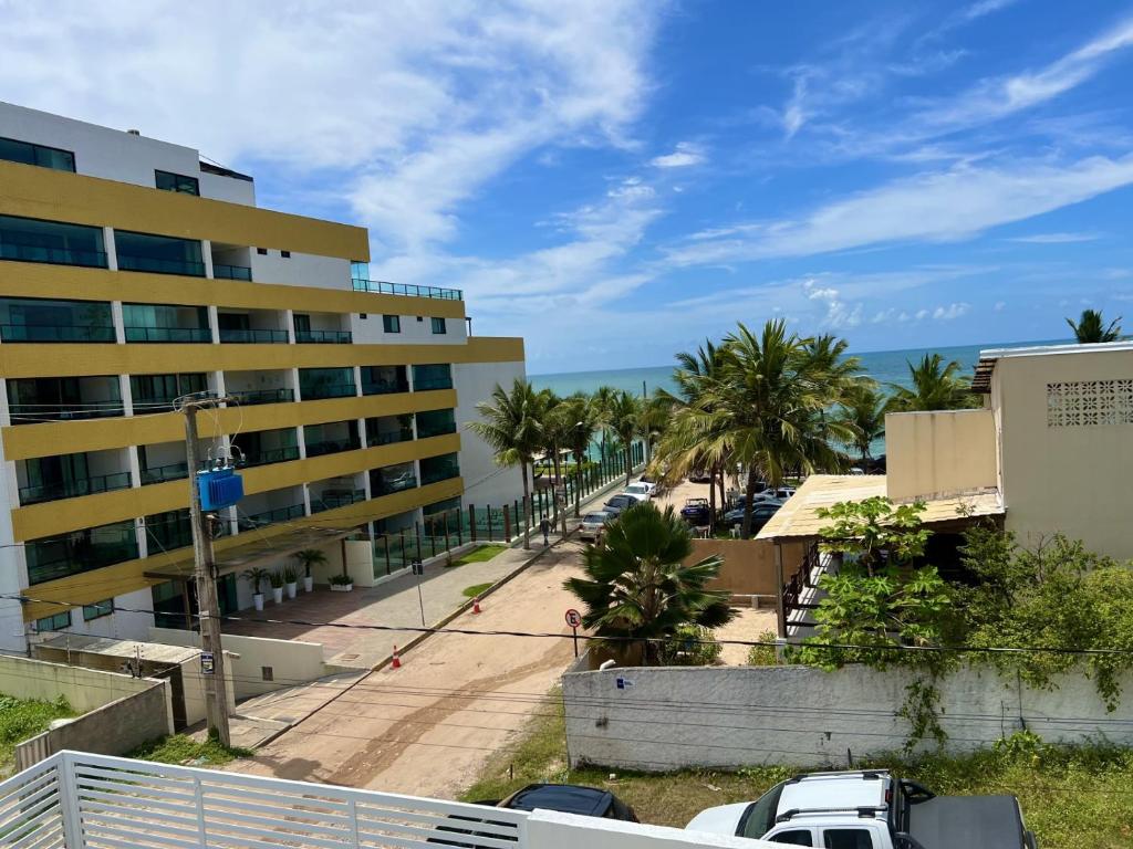 a building with a parking lot next to a street at Casa em FRENTE À PRAIA, ao lado do Nord Hotel - Tabatinga in Conde