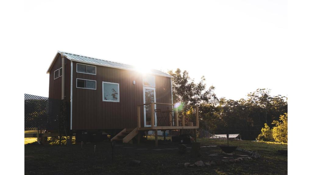 una piccola casa in un cortile con il sole che splende di Kookaburra Tiny House by Tiny Away a Palmwoods