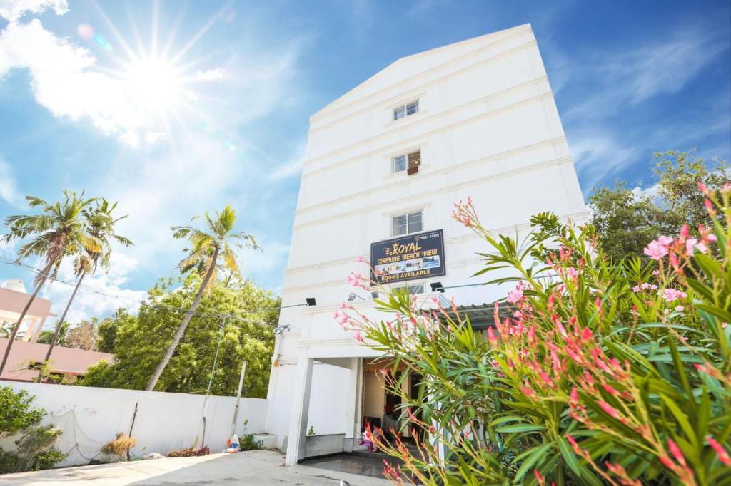 a white building with flowers in front of it at Royal Dreams Beach View in Pondicherry