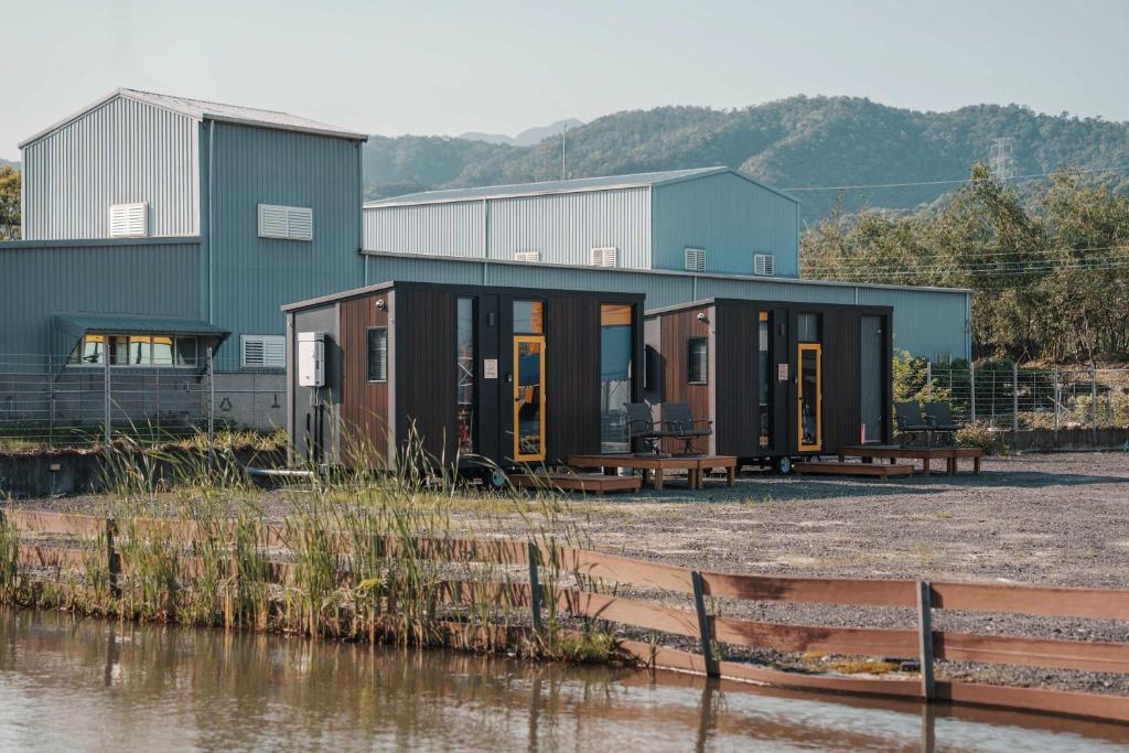 a row of modular homes next to a body of water at Lantian Cottage X by Tiny Away in Chen-shan-ts'un