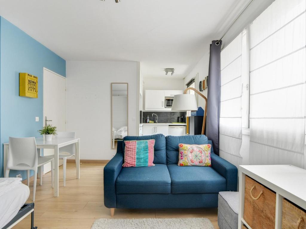 a living room with a blue couch and a table at Quiet studio between train stations and the Opera. in Lille