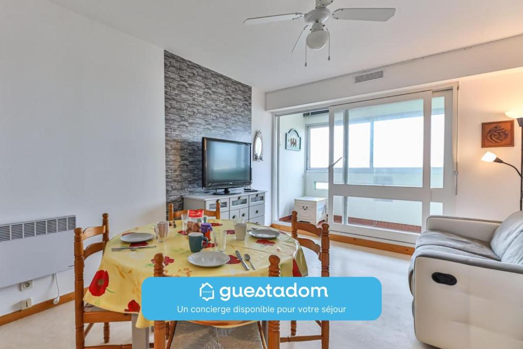 a living room with a table and a tv at L'Albatros - 50m plage - Parking in Plage-des-Demoiselles