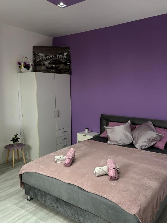 a bedroom with purple walls and a large bed at Apartman LILLY in Paraćin