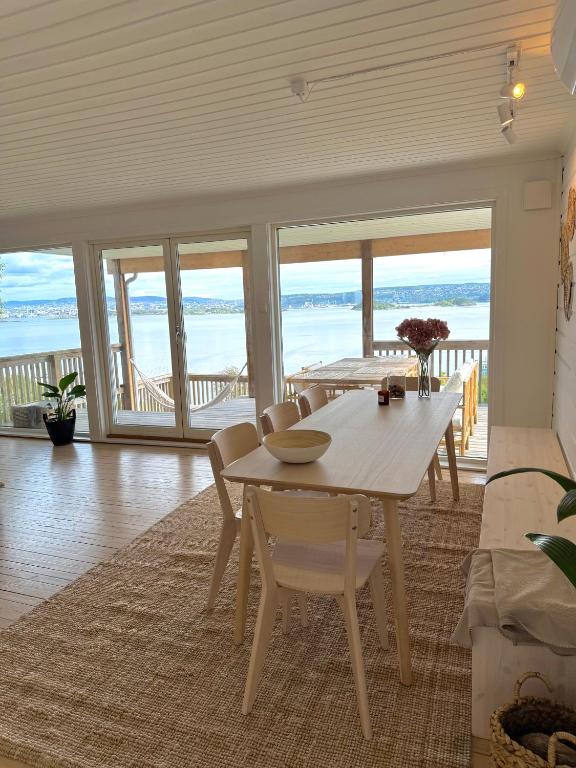 a dining room with a table and views of the ocean at Cherfull 2 bedrooms in Oksval