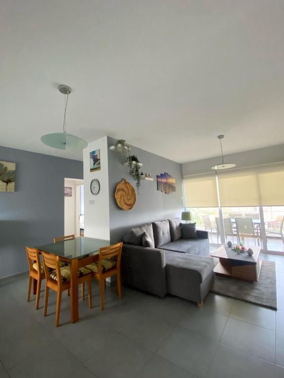 a living room with a couch and a table at STAY Peyia Sunset Pearl in Peyia