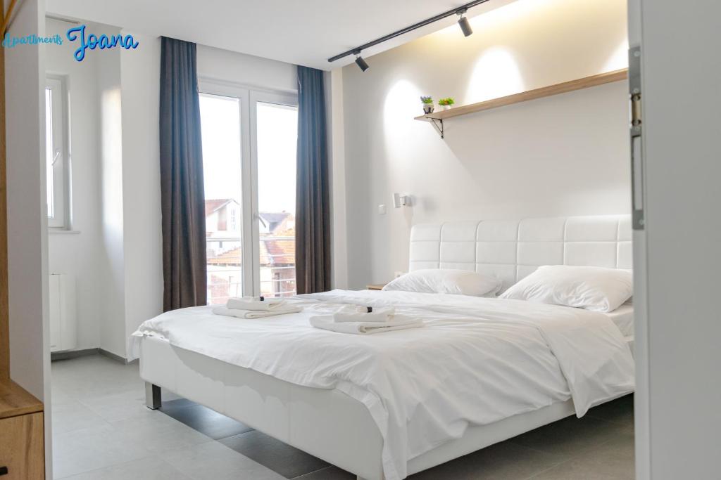 a bedroom with a large white bed with two trays on it at Apartments Joana in Ohrid